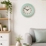 Pale blue wall clock above sofa with soft cushions and home decor