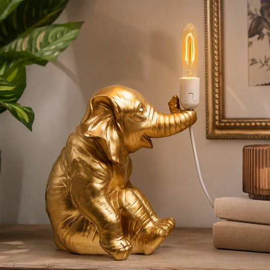 Gold elephant table lamp with exposed bulb on decorative side table