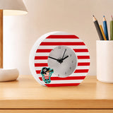 Colourful tabletop clock with red frame and pencils on desk
