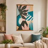 Colourful abstract canvas wall art with bold botanical and geometric shapes displayed above a neutral sofa
