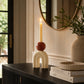 Cream decorative candle holder with arch design, brown sphere detail and tall taper candle