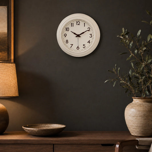 Cream wall clock above wooden side table with plant and decor