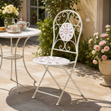 Cream metal outdoor chair with floral pattern beside garden table