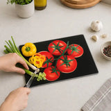Black glass chopping board used for preparing tomatoes, peppers and spring onions