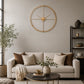 Gold metal wall clock with open frame above sofa and side table