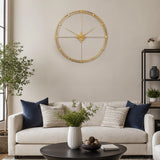 Gold finish metal wall clock above sofa with neutral living room decor