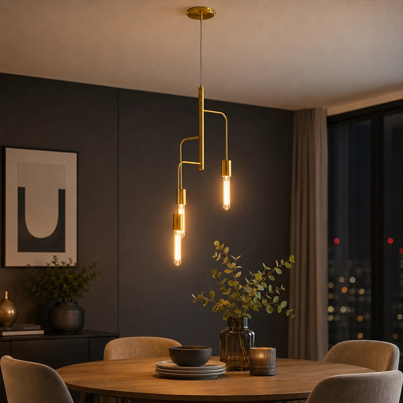 Gold metal pendant light with three exposed bulbs above round dining table