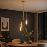 Gold metal pendant light with three exposed bulbs above round dining table