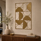 Gold metal geometric wall art with curved abstract shapes displayed above a wooden console table