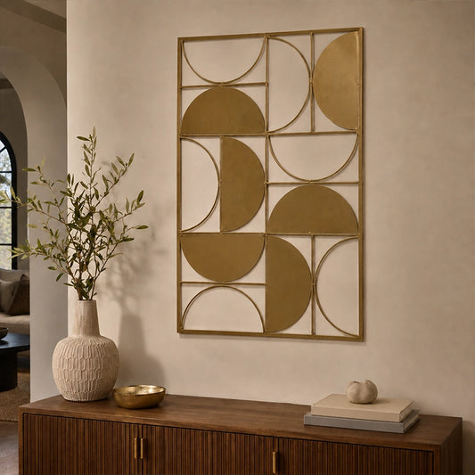Gold metal geometric wall art with curved abstract shapes displayed above a wooden console table