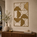 Gold metal geometric wall art with curved abstract shapes displayed above a wooden console table