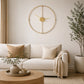 Gold metal wall clock with open face above sofa and round coffee table
