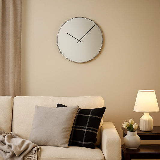 Gold mirrored wall clock above sofa with cushions and table lamp