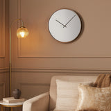 Gold mirrored wall clock above armchair in warm neutral living room