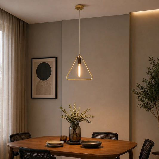 Gold triangle pendant light hanging over round dining table