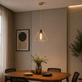 Gold triangle pendant light hanging over round dining table