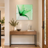 Green floral glass wall art with an abstract leaf design styled above a wooden hallway console