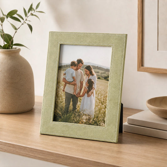 Green photo frame with textured border displayed on wooden shelf