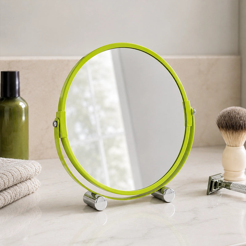 Green round shaving mirror on bathroom counter with plant reflection