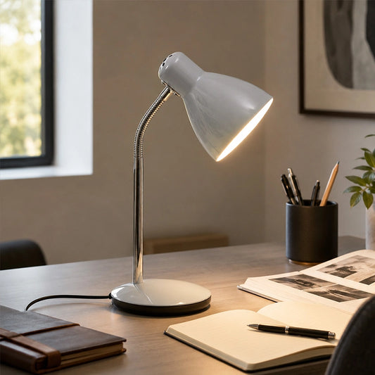 Grey desk lamp on office table with notebook, pens and books