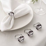 Grey diamante napkin rings on white folded napkins in an elegant table setting