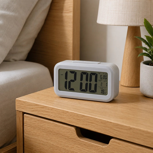 Grey digital clock on wooden bedside table beside neutral bedding