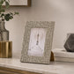 Grey decorative photo frame with patterned design on white surface