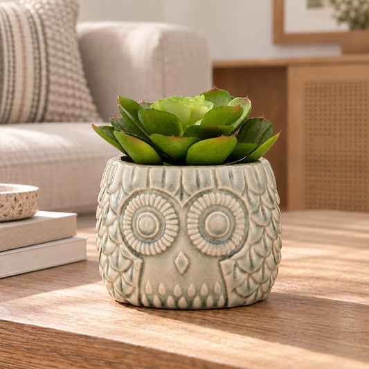 Large artificial succulent in a dark geometric ceramic pot displayed in a modern indoor space