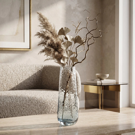 Large blue glass vase with dried foliage and decorative branches in a neutral living room