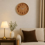 Large brown wall clock above side table with lamp and vase