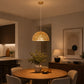 Large gold pendant light over round dining table in modern home interior