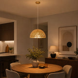 Large gold pendant light over round dining table in modern home interior