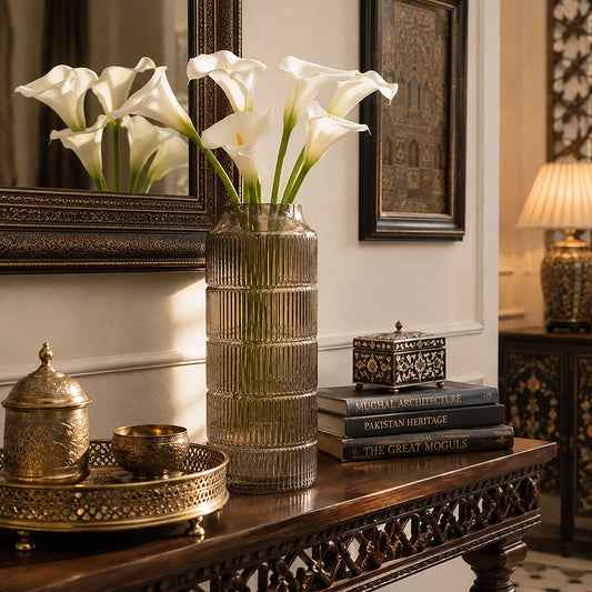 Large grey ribbed vase filled with white calla lilies displayed on a wooden console table