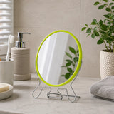 Large green shaving mirror on bathroom counter beside toiletries