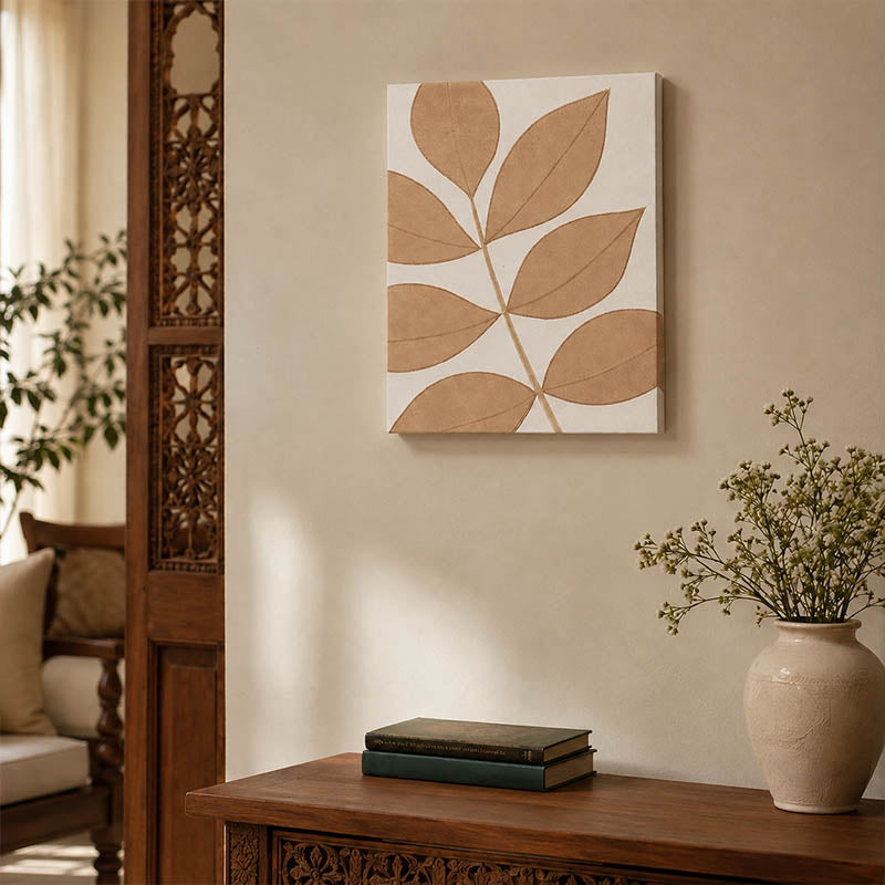 Neutral leaf design wall art in beige and white styled above a carved wooden console table