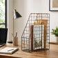 Black wire magazine holder with wooden base beside office desk