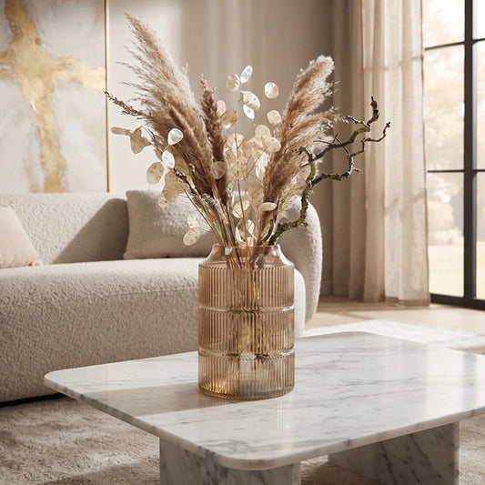 Medium grey ribbed glass vase with pampas grass and dried foliage on a marble coffee table