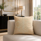 Natural beige decorative cushion with textured embroidered pattern on a cream sofa