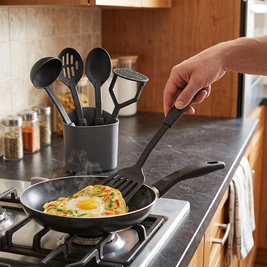 Nylon Kitchen Utensils Set of 5 with black spatula cooking fried egg in non-stick pan on gas stove