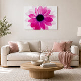 Pink floral wall art featuring a bold flower design displayed above a neutral living room sofa