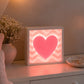 Pink heart LED light box on bedroom dresser with soft warm glow