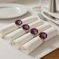Purple diamante napkin rings with faceted crystal design styled on white table napkins