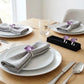 Purple square diamante napkin rings on folded grey linen napkins, elegant dining table setting