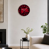 Red glass wall clock with black numbers above sofa and red cushions