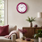 Red plastic wall clock above sofa in warm living room decor