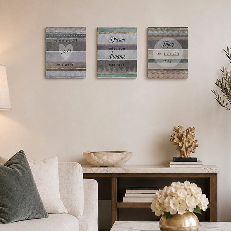 Set of three decorative wooden wall plaques with motivational quotes displayed above a console table