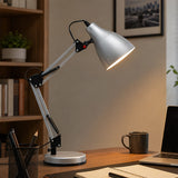 Silver adjustable desk lamp on office desk with mug and stationery