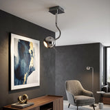 Silver metal ceiling light with curved arm and globe shade in modern living room interior