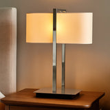 Silver table lamp with rectangular white shade on wooden side table