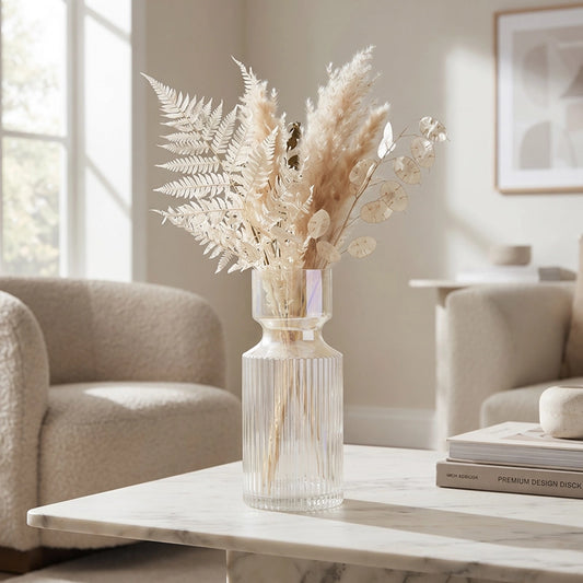 Small clear ribbed glass vase with neutral dried flowers on a marble coffee table